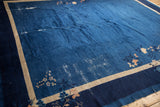 Indigo field, copper and ivory blossoms, beige border, and worn end of vintage Peking carpet.