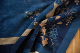 Folded vintage Chinese Peking carpet, indigo blue, delicate blossoms, and visible knot wear.