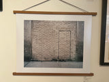 Joe Farrell's Avenue A color photograph displayed on a wall in a wooden poster hanger.