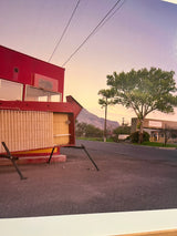 Color photograph by Joe Farrell of a red roadside arrow sign in New Mexico at twilight.