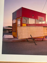 Angled shot of the weathered red and yellow building against a soft pastel sky in New Mexico.