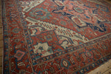 Madder red turtle samovar border and polychromatic selvage on an Antique Serapi carpet corner.