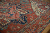 Serapi carpet's madder red field, navy turtle samovar border, teal and blush motifs.