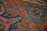 Antique Serapi carpet with time-softened madder red, navy blue, and blush palmettes.