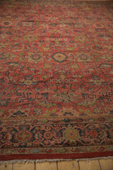 Close-up of vintage Mahal carpet's madder red field, scrolling floral design, and even wear.