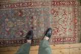 Distressed Persian Yezd runner with faded blue and red floral blossoms and intricate tendrils.