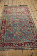 Distressed Yezd rug runner's side showing tattered edge, worn pile, and intricate vine border.