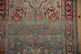 Distressed Persian Yezd runner with faded blue field, red blossoms, and detailed border.