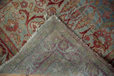 Distressed vintage Yezd runner corner reveals faded blue, red floral pile, woven foundation.