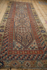 Full length perspective of an antique Serab runner with geometric double medallions on a camel ground.