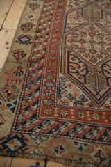 Corner detail of an antique Serab runner with crab motifs and intricate geometric borders in camel and red.