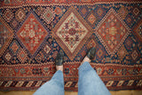 Detailed perspective of an antique Afshar rug's geometric medallions and hidden animal motifs.