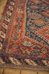 Detailed geometric borders and time-softened pile of a cherry red antique Afshar rug runner.
