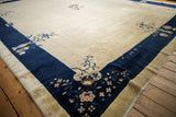 Vintage Peking carpet showcasing soft beige field and cobalt blue pictorial border.