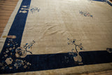 Vintage Peking rug corner with cobalt blue border and floral vase design.