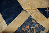 Folded vintage Chinese Peking hand-knotted carpet shows soft cobalt blue pile, woven beige foundation, floral motifs.