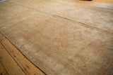 Faded rose and beige allover patterns on the worn pile of the distressed Oushak.