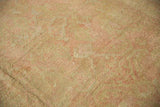 Soft, distressed Oushak wool pile revealing knot heads and blush pink.