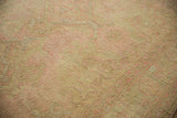 Distressed Oushak carpet close-up, revealing soft wool pile and knot heads in beige and pink.