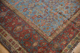 Wide, madder root red border with intricate vinery beside the powder blue Herati field of a Fereghan carpet.