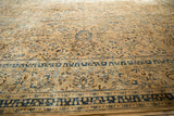 Distressed Persian Meshed rug with sand field, indigo palmettes, soft luster.