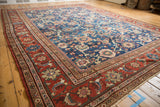 Vintage Mahal carpet corner: madder red contoured floral border, sapphire blue field.