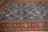 Hand knotted Persian Mahal carpet detail with sapphire blue field, madder red border, and curvilinear floral vinery.