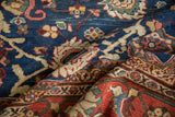 Folded vintage Mahal carpet showcasing hand-knotted Harshang floral motif in jewel tones.