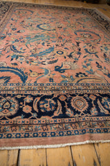 Vintage Laristan carpet's dusty rose field, oversize navy scrolled vines, and an intricate blue border.