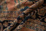 Curvilinear navy blue vines and dusty rose field on folded vintage Laristan rug.