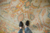 Worn vintage Oushak carpet texture with palmette motifs in ivory, saffron, blush, and teal.