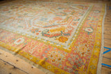 Hand-knotted Oushak rug border showing palmettes in saffron yellow, blush, and dusty teal.