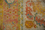 Hand-knotted vintage Oushak detail: saffron yellow palmettes, blush, dusty teal geometric motifs.