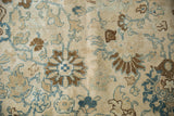 Close-up of distressed pile on a vintage Tabriz with blue and coffee brown hand-knotted floral motifs.