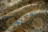 Soft, distressed texture of a vintage Tabriz with dusty blue and coffee brown palmettes.