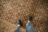 Distressed Sivas carpet, dark brown Herati pattern on beige with visible main border.