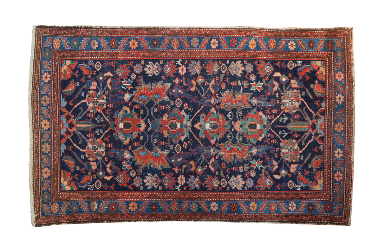 Vintage Persian Malayer rug with an allover gem-tone floral and bird design on a navy blue field.