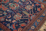Close-up on the gem-toned floral motifs and low pile of a vintage Persian Malayer rug.