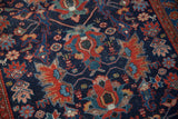 Intricate gem-toned floral motifs in red, blue, and green on a vintage Malayer rug's navy field.