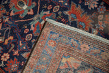 Flipped corner of a vintage Malayer rug revealing its hand-knotted back and colorful pile.