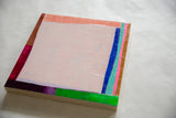 Textured pale pink surface of Sarah Martinez abstract art with vibrant color block edges.