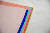 Textured surface of abstract acrylic painting with pink, blue, teal, and brown layers.