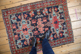 Vintage Persian Karaja rug with geometric medallions in navy, red, and blue shown to scale.