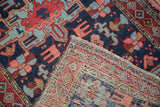 Hand-knotted wool pile and the woven foundation of a vintage Persian Karaja rug's corner.