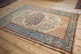 Angled view of the entire vintage Persian Malayer rug, showcasing its oversized scalloped medallion and worn texture.