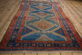 Dusty teal abrashed field with arrowed finials, framed by madder red and indigo borders.