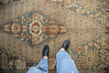 View of distressed Bibikabad rug's intricate palmette and animal motifs in teal, sand, and red.