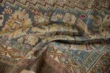 Distressed Bibikabad carpet showing worn pile texture and muted teal, gold, red patterns.