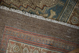 Distressed Bibikabad carpet's back foundation and fringed edge, revealing a madder and teal geometric border.