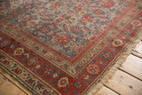 Antique Malayer rug's Herati pattern, with faded slate blue, cherry red, and visible tattered edge.